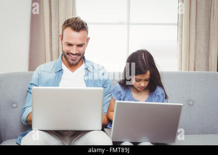 Father and daughter using laptop at home Stock Photo
