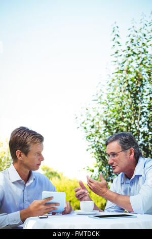 Two businessmen meeting in a restaurant using tablet Stock Photo