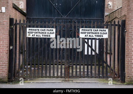 Security Gates with signs saying 'Private car park. Keep entrance clear at all times'. Stock Photo