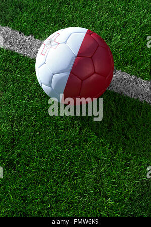 Soccer ball and national flag of Malta lies on the green grass Stock Photo