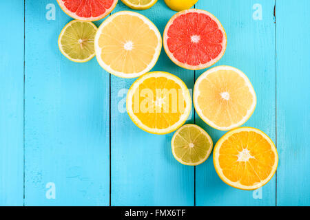 Lemon, Orange, Grapefruit And Lime Citrus Fruit Slices On Turquoise Table Stock Photo