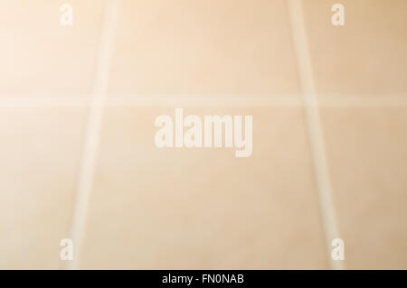 Blurred of cream tile floor with window light from the left Stock Photo
