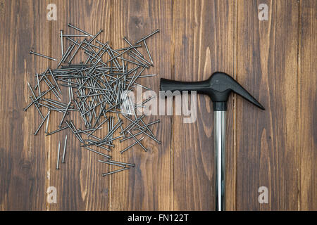Hammer and nails on brown deck, hand made work tools Stock Photo