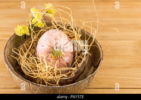 Decorated Easter eggs in a coconut shell as a bowl Stock Photo
