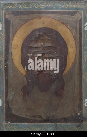 Badly damaged Orthodox icon of the Saviour Made Without Hands on the Grave of Russian engineer Nikolai Ipatiev in the underground crypt of the Dormition Church at the Olsany Cemetery in Prague, Czech Republic. Engineer Nikolai Nikolayevich Ipatiev (1869 - 1938) was an owner of the notoriously Ipatiev House in Yekaterinburg, Russia, where Tsar Nicholas II and his family were killed in July 1918 by the Bolsheviks. Engineer Ipatiev lived in exile in Czechoslovakia afterward and died on April 20, 1938. The Dormition church at the Olsany Cemetery was built in 1924-1925 by the Russian white emigre. Stock Photo