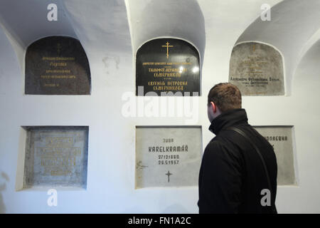 Russian historian Konstantin Gerbeev examines the burial place of Karel Kramar, the first Prime Minister of Czechoslovakia, in the underground crypt of the Dormition Church at the Olsany Cemetery in Prague, Czech Republic. Karel Kramar, born on December 17, 1860, was a Czech (Bohemian) politician and the first Prime Minister of Czechoslovakia from November 1918 to July 1919. He died at age 76 on May 26, 1937, and was buried next to his Russian wife Nadezhda Kramar, who died five months earlier at age 73. Grave of Russian art historian Nikodim Kondakov is seen at the left. Stock Photo