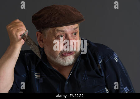 Malicious senior man holding rusty knife Stock Photo