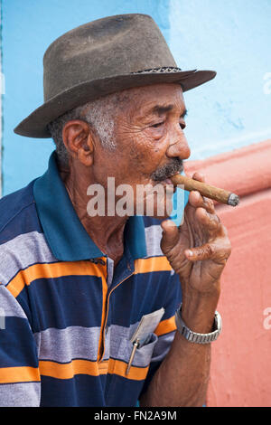 Daily life in Cuba - Cuban man smoking cigar at Trinidad, Cuba, West Indies, Caribbean, Central America in March Stock Photo
