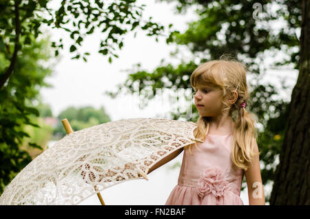 little blond girl  holding white sunshade Stock Photo