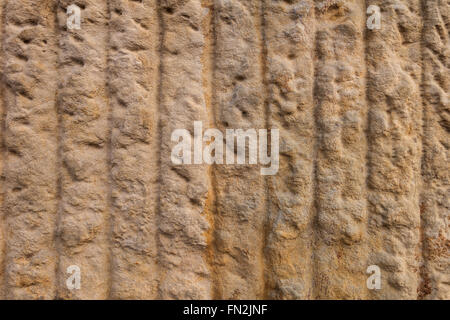 Abstract brown texture of sandstone with hewn vertical lines in a coarse surface. Taken in close-up. Stock Photo