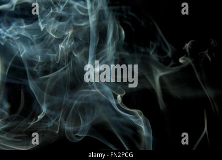 Gestures smoke in the blue and white isolated on black background, interesting, abstract background. Horizontal view. Stock Photo