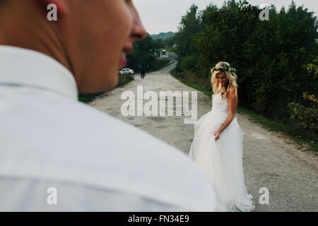 bride leads groom on the road Stock Photo