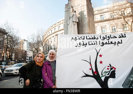 London, UK. 13th March, 2016. A small group or people hold a planting action celebrating and commemorating Syrian women at the Edith Cavell Memorial in Central London. 13 March 2016. Credit:  Noemi Gago/Alamy Live News Stock Photo