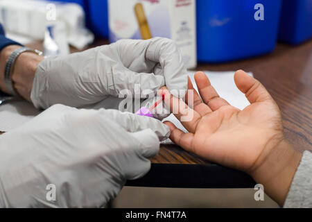 Flint, Michigan - A volunteer nurse collects a blood sample from a three-year-old girl to test for lead exposure. Stock Photo