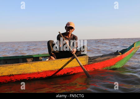 Fisherman smoking on the long boat on the Mekong River, Siem Reap Cambodia. Stock Photo