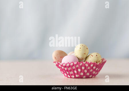 Closeup of chocolate speckled Easter eggs in a crisp sugar shell in cupcape liner with copy space Stock Photo