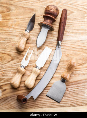 Cheese knives on the wooden background. Stock Photo