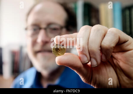 Jerusalem, Israel. 14th March, 2016. Dr. DONALD ARIEL, Head Curator of the Coin Department at the Israel Antiquities Authority, holds a rare gold coin bearing the image of Emperor Augustus. Minted in Rome in 107 CE the coin was part of a series minted by Emperor Trajan as a tribute to Roman emperors that preceded him. The coin, discovered by a hiker in Israel’s North, is an identical twin to a coin owned by the British Museum and until now believed to be the only one of its kind known in the world. Credit:  Nir Alon/Alamy Live News Stock Photo