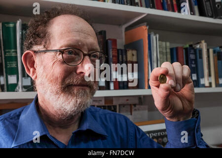 Jerusalem, Israel. 14th March, 2016. Dr. DONALD ARIEL, Head Curator of the Coin Department at the Israel Antiquities Authority, holds a rare gold coin bearing the image of Emperor Augustus. Minted in Rome in 107 CE the coin was part of a series minted by Emperor Trajan as a tribute to Roman emperors that preceded him. The coin, discovered by a hiker in Israel’s North, is an identical twin to a coin owned by the British Museum and until now believed to be the only one of its kind known in the world. Credit:  Nir Alon/Alamy Live News Stock Photo