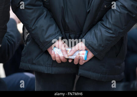 Chinese man holding card with chinese script behind his back Stock Photo