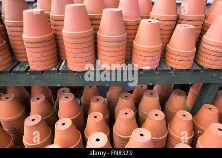 Terracotta plant pots stacked on top of each other on a shelf. Stock Photo