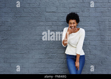 Woman Laughing against wall Stock Photo - Alamy