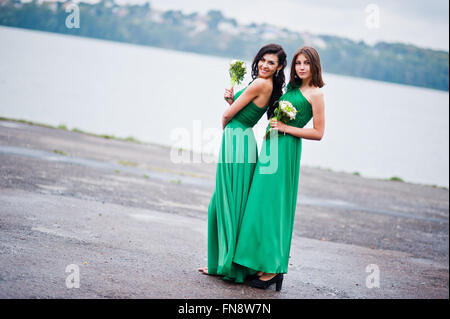 Two charmed girls bridesmaids on green dress Stock Photo