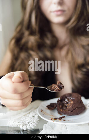 Young woman eating chocolate dessert Stock Photo