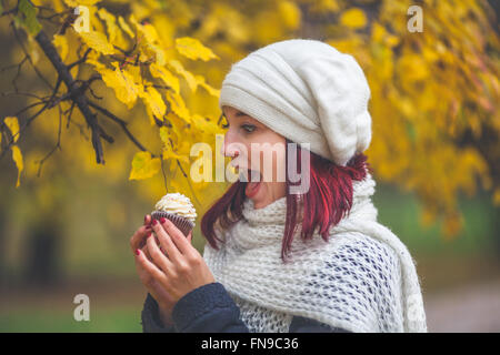 Portrait of a woman holding cupcake in the park Stock Photo