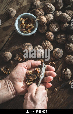 Close up of a senior woman cracking walnuts Stock Photo