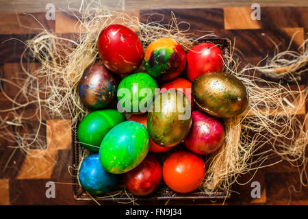Colorful Easter eggs inside a nest on the kitchen table Stock Photo