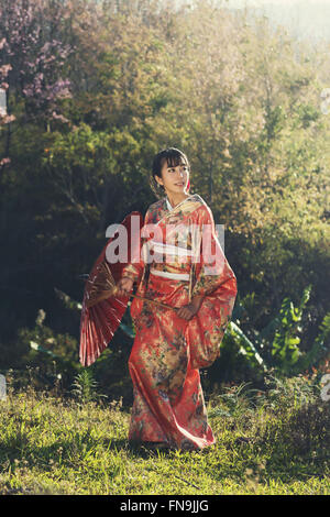 Woman in kimono standing in field Stock Photo