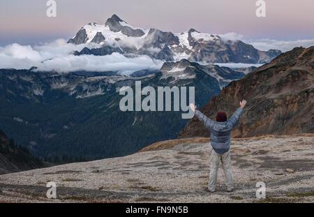 Man standing with arms raised, Mount Shuksan, Washington, United States Stock Photo
