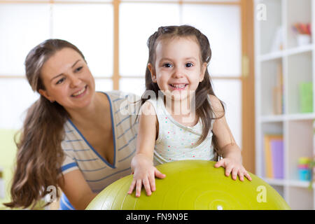 mother and her child having fun with gymnastic ball Stock Photo