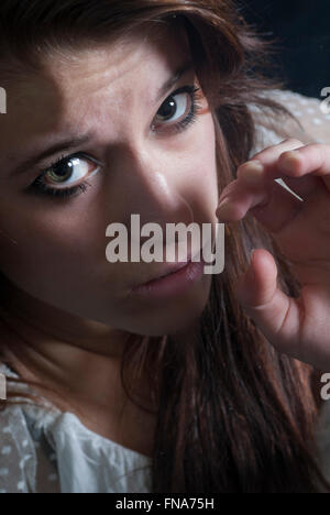 Close up of a scared young woman hand pushing against the glass Stock Photo