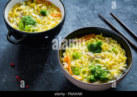 Asian egg noodle soup with vegetables and pork on dark slate background. Top view Stock Photo