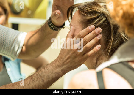 Professional Cosmetologist Applying Anti-aging Ointments on Woman Face, near Eyes Stock Photo