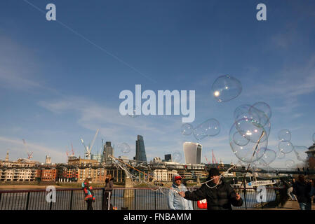 Bubble blowing street entertainer with City of London skyline in background Stock Photo