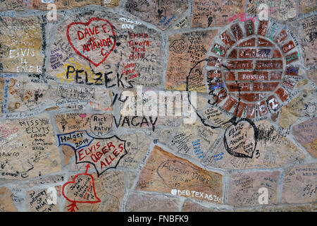 Visitors scrawl messages on the stone fence in front of Graceland, Elvis Presley's home and now a museum in Memphis Tennessee. Stock Photo