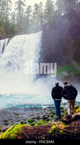 Two men explore Koosah Falls in Oregon along the historic McKenzie River. Stock Photo
