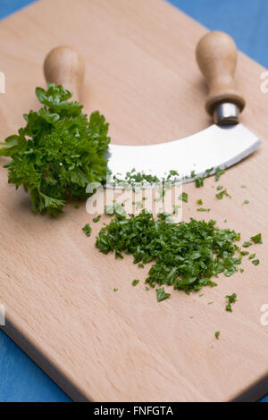 https://l450v.alamy.com/450v/fnfgta/petroselinum-crispum-curly-parsley-on-a-wooden-chopping-board-fnfgta.jpg