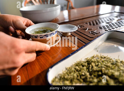 (160315) -- SUZHOU, March 15, 2016 (Xinhua) -- Yan Jielong makes Biluochun tea in Dongshan Town, Suzhou City of east China's Jiangsu Province, March 14, 2016. Yan Jielong, 53 years old, inheritor of ancient making technique of Chinese tea Biluochun, has learnt the skill since he was 16 years old. Requiring high standard of making technique, Biluochun tea is the speciality of Dongshan Town, where the people who know the ancient making technique are mostly in their 50s. Yan and other inheritors have taken video of their method and hope they may someday open a school for it and pass on the techni Stock Photo