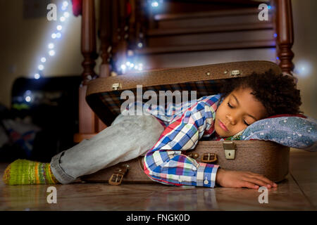 Cute boy sleeps in suitcase. Stock Photo