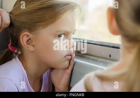 The girl glared at the other girl sitting near electric windows Stock Photo