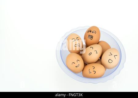 Eggs with smiling happy faces on plastic bowl, isolated on white background Stock Photo