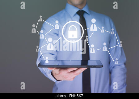 Businessman holding a tablet. with touch screen interface and cyber security concept . Stock Photo
