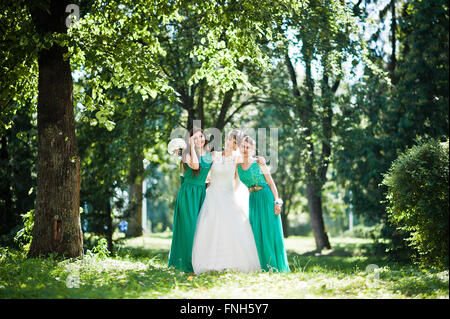 Gorgeous bride with bridesmaids posed on sunshine park Stock Photo