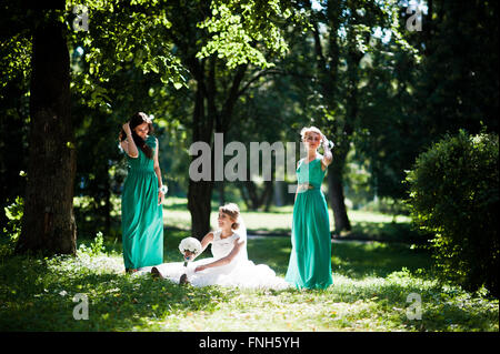 Gorgeous bride with bridesmaids posed on sunshine park Stock Photo