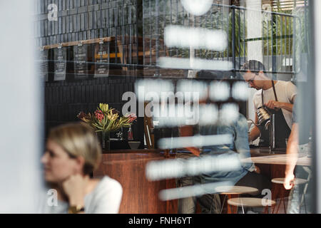 Window of a trendy coffee shop with reflections and people Stock Photo