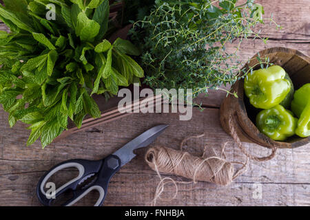 Fresh herbs ,bell pepper ,scissors on wooden background Stock Photo